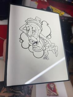 a person holding up a book with a drawing on it