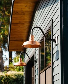 two copper colored lights on the outside of a building