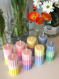 colorful candles sitting on a table next to flowers