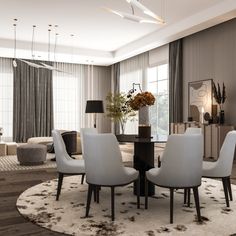 a dining room with white chairs and a round rug on the floor in front of a large window