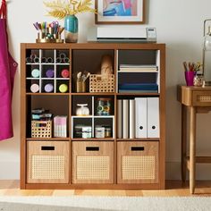 a wooden shelf filled with lots of books and crafting supplies on top of a hard wood floor