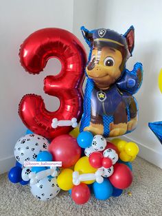 balloons and heliums are arranged in the shape of an animal, which is wearing a hat