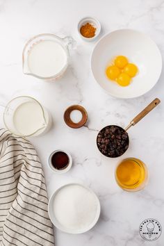 ingredients to make an orange smoothie laid out on a marble counter top, including eggs, milk, sugar and cinnamons