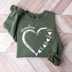 a green sweatshirt with the words grandma written on it and hearts drawn in white ink