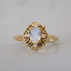 The Moonstone Regalia Ring is a blend of mystical beauty and regal sophistication. Featuring a captivating natural moonstone set in an intricate Byzantine-inspired design Available in 14K solid yellow gold, rose gold or white gold. This ring is designed and made in New York City. Create the ultimate stack with our Goddess ring band. 14K solid gold Natural oval moonstone, 6*4mm Natural white diamonds 1.5mm band thickness **This item is specially made for you. Please allow 1-2 week lead time. Shipping:Domestic: Free standard shipping within the U.S.International: Free standard shipping for orders over $200 Customization:- Interested in customizing this item? See our special order page here to start. - Not sure what your ring size is? See our conversion chart here. *For custom size, simply in Heirloom Moonstone Ring With Rose Cut Diamonds For Promise, Heirloom Style Moonstone Ring With Rose Cut Diamonds, Heirloom Moonstone Ring With Rose Cut Diamonds, White Celestial Moonstone Ring In 14k Gold, White Moonstone Celestial Ring In 14k Gold, Heirloom Moonstone Ring With Rose Cut Diamonds For Anniversary, Heirloom Gold Opal Gemstone Ring, Heirloom Gold Moonstone Jewelry, Celestial 14k Gold Opal Wedding Ring