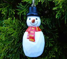 a snowman ornament hanging from a tree