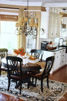 a dinning room table with chairs and a chandelier hanging from the ceiling