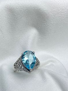 Simulated Sky Blue Aquamarine Gemstone Teardrop RingTear Lace Design#D222 Embrace timeless elegance with this stunning Antique Reproduction ring, inspired by the intricate designs of the Victorian and Art Deco eras. Crafted from premium sterling silver, this exquisite piece showcases a flawless, pear-cut simulated Aquamarine gemstone, measuring 12mm by 10mm. The vibrant blue hue of the aquamarine adds a touch of sophistication and charm. The inside of the band is stamped with 925, confirming its Blue Aquamarine Ring, Teardrop Ring, Aquamarine Stone, Aquamarine Gemstone, Aquamarine Rings, Aquamarine Blue, Art Deco Era, Victorian Jewelry, Lace Design