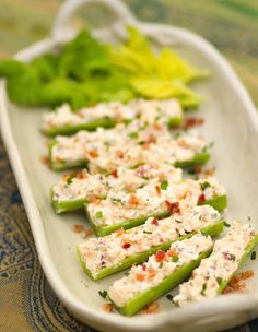 celery sticks with cheese and lettuce on a white platter next to lettuce leaves