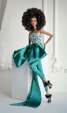 a barbie doll wearing a green dress and high heeled shoes, leaning against a wall