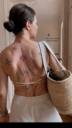 a woman with tattoos on her back holding a basket