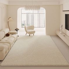 a living room with white furniture and a large rug on the floor in front of a window