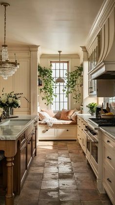 a kitchen filled with lots of counter top space next to a stove top oven under a chandelier