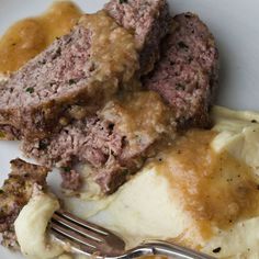 meatloaf, mashed potatoes and gravy on a plate with sauce