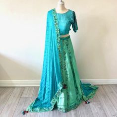 .Beautiful dupatta in a pure georgette turqoise fabric with sea green silk boarder with intricate hand embroidery  .Raw silk turquoise blouse with fully hand embroidered sleeves .Back of this unique backless design choli blouse in raw silk turqoise material .A unique custom made lahenga in sea green and turquoise raw silk material and georgette dupatta. All the work is fully hand embroidered . A vibrant raw silk lahenga in a turquoise and sea green colour with full hand embroidery Green Raw Silk Sharara With Dori Work, Green Raw Silk Traditional Wear With Sheer Dupatta, Green Chanderi Lehenga With Cutdana, Green Raw Silk Anarkali Set With Dori Work, Green Raw Silk Anarkali Set With Sheer Dupatta, Silk Green Choli With Sheer Dupatta, Green Raw Silk Choli With Cutdana, Green Anarkali Silk Choli, Festive Turquoise Sheer Dupatta