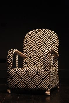 a black and white patterned chair sitting on top of a wooden floor