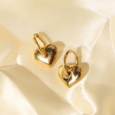 Embrace the sweet elegance of Heart Charm Earrings, beautifully crafted in 18k gold plating. These earrings feature charming heart charms, perfect for adding a touch of love and sophistication to any ensemble. Tarnish Resistant Gold Plated Dainty Heart Earrings, Elegant Heart Charm Huggie Earrings, Elegant Huggie Earrings For Valentine's Day, Elegant Gold Plated Heart Earrings As Gift, Elegant Gold Plated Heart Pendant Earrings, Valentine's Day Tarnish Resistant Drop Earrings, Gold Heart-shaped Huggie Earrings For Everyday, Elegant Heart Huggie Earrings For Everyday Wear, Gold Plated Double Heart Charm Earrings