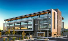 an office building with many windows on the front and side of it, along with parking lot