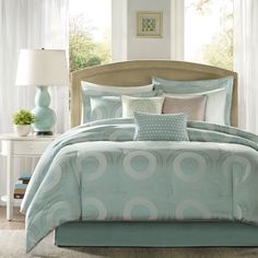 a bed with blue and white comforters in a bedroom