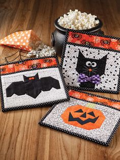 three halloween placemats with black cats and bats on them