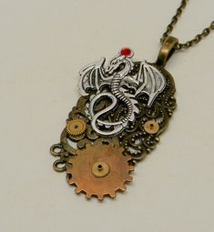 "Awesome steampunk pendant of a dragon and gears mounted on brass Victorian filigree. The size is 2\" by 1\" and it has antique brass chain 24\".All my jewelry come in a nice gift box. More steampunk pendants in my shop www.etsy.com/shop/slotzkin" Fantasy Brass Jewelry For Gifts, Metal Dragon Design Jewelry Gift, Metal Jewelry With Dragon Design As Gift, Metal Jewelry With Dragon Design For Gift, Handmade Steampunk Metal Necklace, Fantasy Bronze Metal Jewelry, Steampunk Metal Round Pendant Jewelry, Steampunk Metal Jewelry With Round Pendant, Antique Dragon Design Jewelry Gift