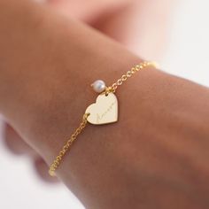 Elevate your style with our Personalized Heart Bracelet! Handcrafted with real pearls, this elegant bracelet is the perfect gift for her on any occasion. Whether it's a birthday, anniversary, or Christmas, this Name Bangle Bracelet adds a touch of sophistication to any outfit. This Name Engraved Bracelet for Mom features a delicate heart charm, adding a sentimental touch to your gift. Personalize it with your loved one's name for a truly special touch. Key Features: * Bracelet measures 16mm * Ma Elegant Wedding Charm Bracelet With Heart Charm, Dainty Pearl Bracelet For Valentine's Day, Gold Heart-shaped Pearl Bracelet For Valentine's Day, Silver Heart-shaped Pearl Bracelet For Gift, Elegant Hypoallergenic Heart Bracelet For Anniversary, Elegant Name Bracelet For Valentine's Day, Heart Charm Bracelets For Wedding And Mother's Day, Elegant Pearl Bracelet With Heart Charm As Gift, Heart Charm Bracelet For Wedding And Mother's Day