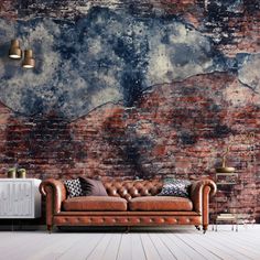 an old brick wall with a leather couch in the foreground and two lamps on either side