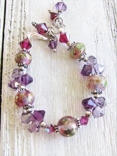 "I bought these GORGEOUS LAMPWORK beads in 2007, and they are some of my very favorites. I bought these from a lampwork artist who made the beads and have combined them with Swarovksi crystals and silver to make what I think is a breathtaking bracelet. There are 5 lampwork beads in this piece, and I have tried to capture them in the closeup pics--each different, but in the same color/style. The lampwork beads are approximately 12mm in diameter, there are 12 purple Swarovski top-drilled bicones, Adjustable Glass Bracelets With Unique Variations, Purple Glass Bracelet, Adjustable Pink Bracelets, Handmade Adjustable Glass Crystal Bracelet, Unique Adjustable Pink Bracelets, Unique Pink Adjustable Bracelets, Adjustable Pink Bracelet, Unique Adjustable Pink Beaded Bracelets, Adjustable Pink Unique Bracelets