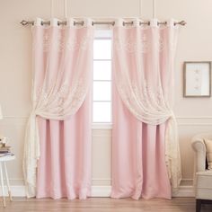 a living room with pink curtains and a white chair in front of the window that has lace trim on it