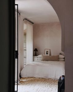 an archway leading to a bedroom with a bed