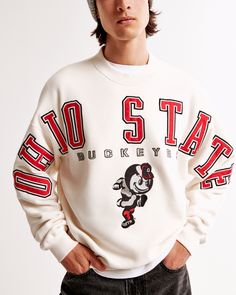 Classic sweatshirt in our softAF fleece fabric and oversized-fit silhouette, featuring The Ohio State University-inspired graphic detail at chest and sleeves, crew neckline and banded hem and cuffs. Cool Mens Clothing, College Graphic Print Crew Neck Shirt, Collegiate Crew Neck T-shirt With Graphic Print, University Red Collegiate T-shirt Crew Neck, Vintage University Crewneck, College Sweater, Abercrombie Patchwork Hoodie, Abercrombie Men, College Sweatshirt