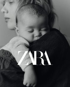 a woman holding a baby in her arms with the word zara written on it