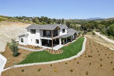 an aerial view of a large house in the middle of a field with lots of grass