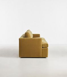 a yellow couch sitting on top of a white floor