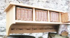 a wooden shelf with wicker baskets hanging from it's sides on a stone wall