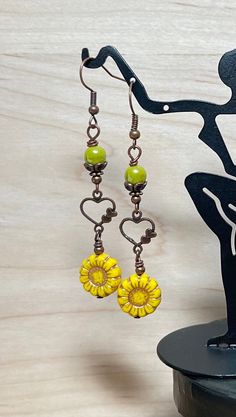 Pretty springtime boho dangle earrings.  These earrings are created using green yellow Czech sunflower beads with a copper wash, avocado green Czech beads, and antique copper heart connectors.  These earrings are great for everyday, and make a lovely gift! Total length of earrings, including the ear wire, is 2-1/2". Thank you for visiting The Lucie Collection! Green Bohemian Jewelry For Spring, Whimsical Green Czech Glass Earrings, Bohemian Flower Earrings With Czech Glass, Bohemian Flower Czech Glass Earrings, Whimsical Yellow Jewelry With Ear Wire, Whimsical Yellow Dangle Earrings, Yellow Whimsical Dangle Earrings, Handmade Bohemian Flower Earrings With Czech Glass, Green Heart-shaped Bohemian Earrings