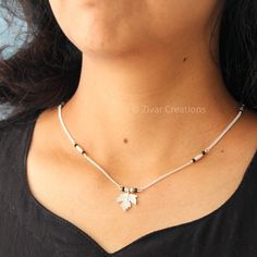 I've incorporated a silver leaf charm as the pendant, creating a beautiful mangalsutra design with a combination of silver rice-shaped beads and glass black beads. The short length ensures visibility. Elevate your style by adorning this beautiful mangalsutra with any ethnic or Indo-western ensemble, guaranteeing a unique and standout presence in the crowd. Sterling Silver Necklace With Black Beads, Silver Spiritual Necklace With Tiny Beads, Spiritual Silver Necklace With Tiny Beads, South Indian Mangalsutra, Mangalsutra Design, Hook Necklace, Silver Wedding Jewelry, Mangalsutra Designs, Indian Necklace