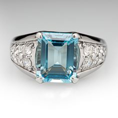 This cool-hued ring is centered with one (1) emerald cut natural aquamarine set into a four-prong setting. The shoulders of the ring are each accented with eight (8) shared bead set round brilliant cut diamonds. The ring measures 10.7mm at the top, rises 6.7mm above the finger, and tapers to 2.9mm wide by 1.0mm thick at the base of the shank. The ring is crafted in platinum and is currently a size 6.25. Modern Topaz Ring With Rectangular Stone For Formal Occasions, Modern Formal Topaz Ring With Rectangular Stone, Emerald Cut Light Blue Jewelry For Weddings, Light Blue Emerald Cut Jewelry For Wedding, Light Blue Emerald Cut Wedding Jewelry, Modern Topaz Ring With Gemstone Accents For Formal Occasions, Elegant Light Blue Aquamarine Diamond Ring, Classic Light Blue Topaz Ring For Formal Occasions, Elegant Emerald Cut Blue Gemstones