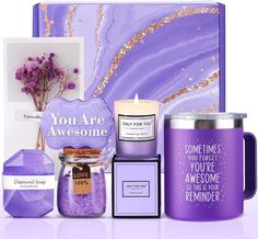 a purple gift box with candles, candle holders and other items