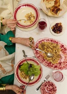 people sitting at a table with plates and bowls of food