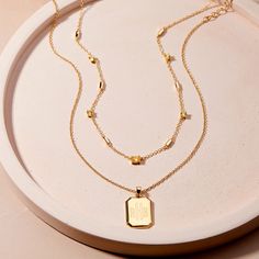 Add a personal touch to your style with the Willow Birthstone Layering Set! This unique set includes a custom birthstone necklace with an engraved pendant, perfect for layering or wearing on its own. This set is both stylish and meaningful. Available in 14k gold plated brass Willow Pendant: Size: 3/4" by 5/8"; Length: 18" cable chain with 2" extender Brenna Birthstone Necklace: Bar station size: 5mm, 3mm cubic zirconia round basket set stone, 6x4mm cubic zirconia oval basket set stone Length: 16 Oval Basket, Dainty Gold Chain, Tennis Jewelry, Bar Station, Necklace Bar, Engraved Pendant, Birthstone Colors, Round Basket, Basket Set