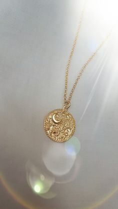 "This Night's Sky coin pendant is etched from original illustrations and is embellished with a tiny crescent Moon and tiny stars. Edged in delicate granulation, this is the perfect delicate gold necklace for layering. The necklace is made from sterling silver and is plated in 18ct yellow gold.  Width of coin: 1.8cm Length of chain: 18\" chain with an adjuster at 16\"" Celestial Crescent Charm Necklace With Delicate Chain, Engraved Moon-shaped Brass Necklace, Engraved Brass Moon Necklace, Engraved Moon Shaped Brass Necklace, Delicate Gold Moon Necklace, Gold Moon-shaped Engraved Necklace, Delicate Moon Charm Pendant Necklace, Gold Coin Pendant Necklace With Moon Charm, Gold Coin Necklace With Moon Charm And Round Pendant