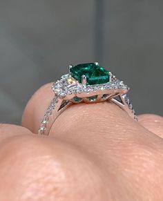 Emerald statement cocktail ring is a great way to create an elegant, princess-like look. The center stone is emerald cut shape and has gorgeous facets. For extra sparkle, 2 Emerald cut side 0.30ctw diamonds and has been framed by 48 round brilliant cut 0.37ctw diamonds forming a beautiful halo around. Metal: 18K white goldDiamond Weight : (48) 0.37ctw Side Diamonds: (2) 0.30ctwEmerald Weight: 1.64ctWidth: 13mm X 15mm Emerald: W 8 mm X L 5.7mm Estimated production time is 4 - 5 weeks Luxury Green Emerald Halo Ring, Diamond Cocktail Ring, Diamond Cocktail Rings, Green Emerald, Emerald Diamond, Cocktail Ring, Cocktail Rings, Emerald Cut, Round Brilliant