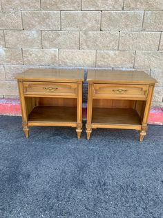 two wooden nightstands sitting next to each other on top of a carpeted floor