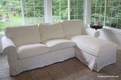 a white couch sitting under a window in a living room