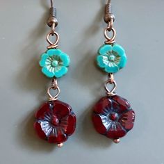 "Red and Turquoise Earrings - Dark Red Czech Glass Flower Beads dangle from Turquoise Czech Glass Flower Beads. Antiqued Copper plated Earwires Earrings measure just over 1.75\" from top of earwires to bottom of beads." Nickel-free Czech Glass Flower Earrings, Czech Glass Flower Earrings With Flower Charm, Red Flower Charm Earrings, Red Flower Earrings With Ear Wire, Adjustable Red Flower Beaded Earrings, Flower Charm Round Bead Earrings For Gifts, Red Bohemian Dangle Flower Earrings, Flower Charm Earrings With Round Beads As A Gift, Flower Charm Earrings With Czech Glass For Gift