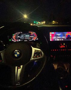 the interior of a car at night, with dashboard lights on and electronic screen showing