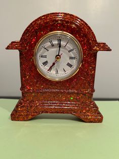 a red clock sitting on top of a table