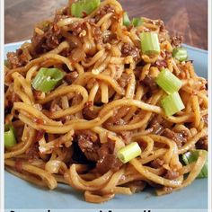 a blue plate topped with noodles and meat