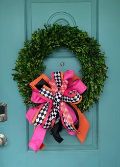 a green door with a pink and black wreath on it